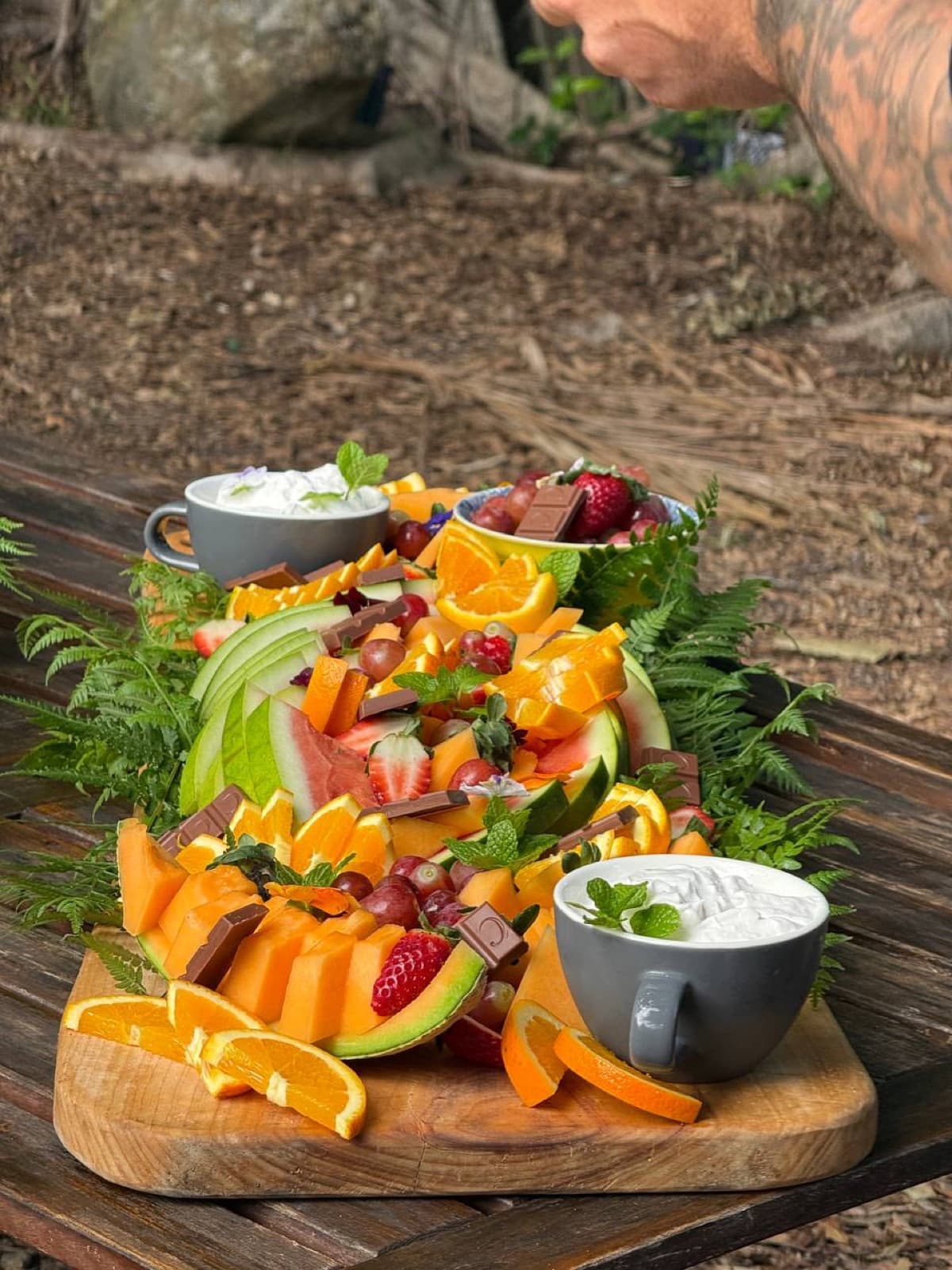 Tropical fruit platter with watermelon, rockmelon, oranges, grapes, berries and a yoghurt dip