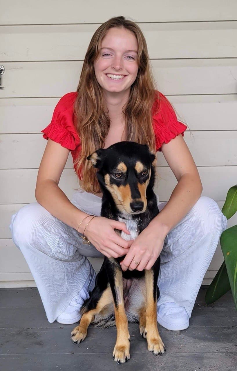 A happy kelpie sitting with its owner on the verandah at Fairhill