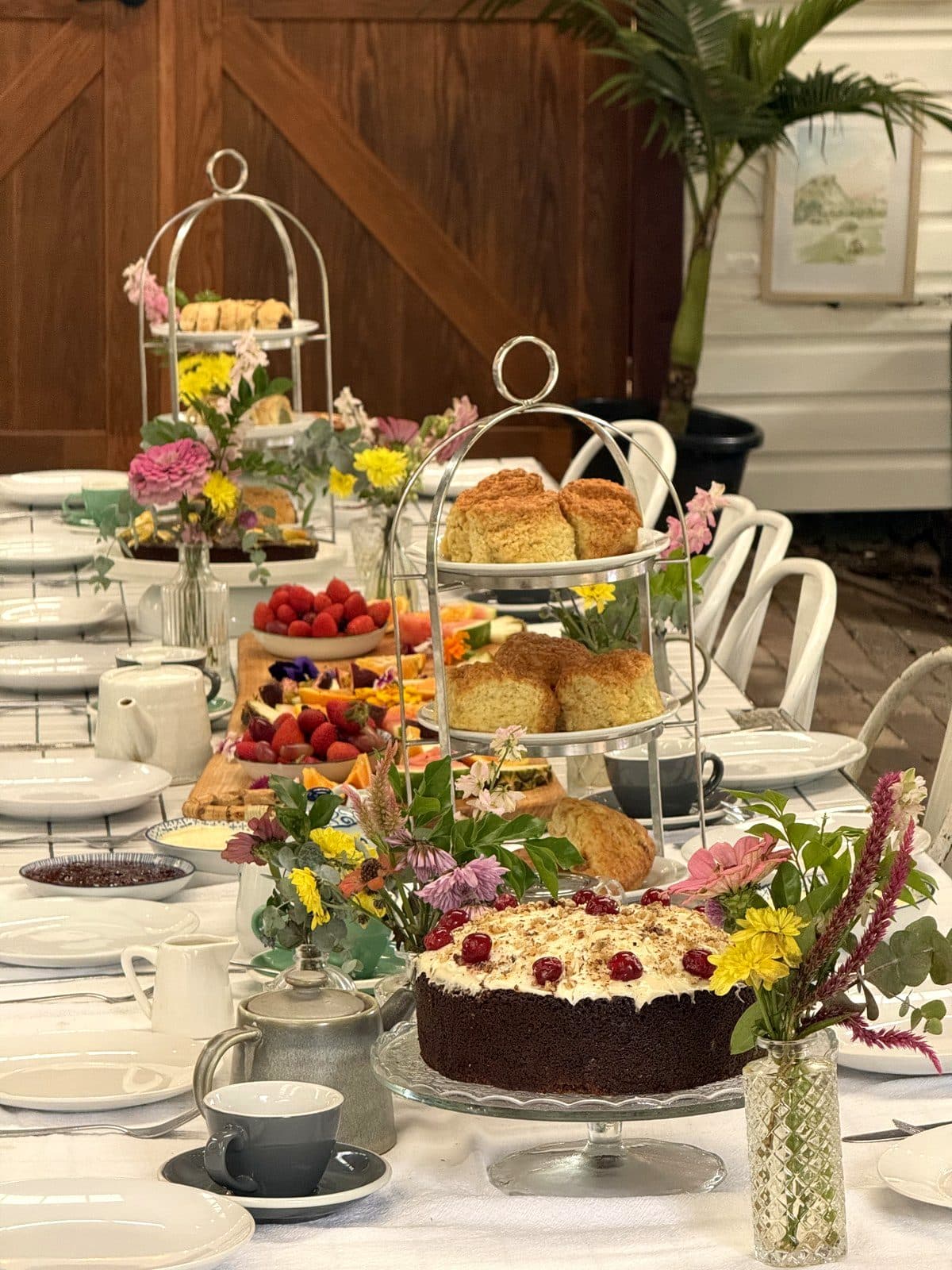 Tiered stands of scones and sweet treats down the dressed table in the Fairhill pavilion, ready for the Bush Harvest Morning Tea