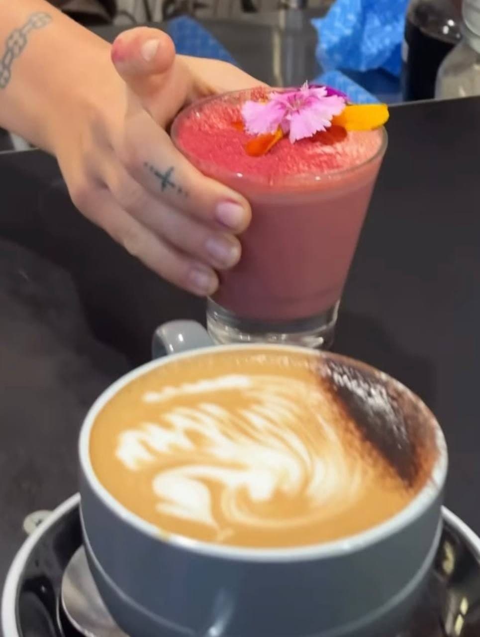 A Fairhill barista finishing a latte and a berry smoothie at the Gardens Cafe